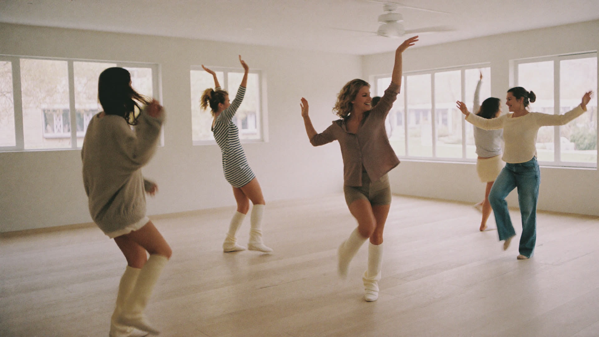 Adults dancing together in a bright, light-filled hall